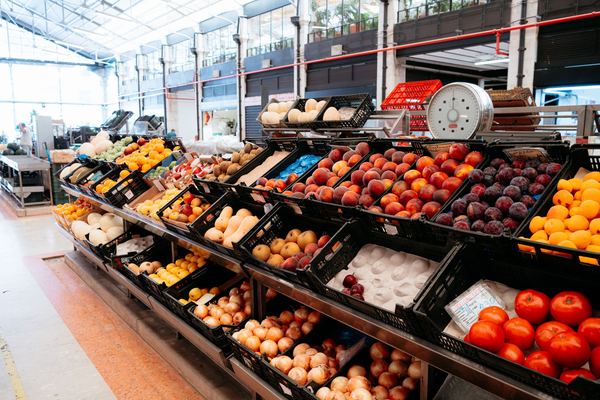 Crates of fresh fruit and vegetables in a bright produce market.