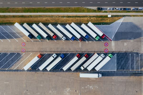 Aerial view of rows of semi-trailers parked at a truck stop.