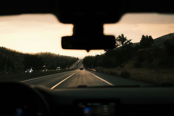 View through a car windshield of a highway at sunset