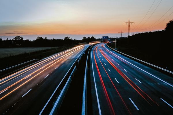 Light trails from cars on a multi-lane highway at dusk