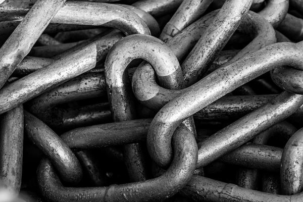 Heavy steel chain links piled together in black and white.