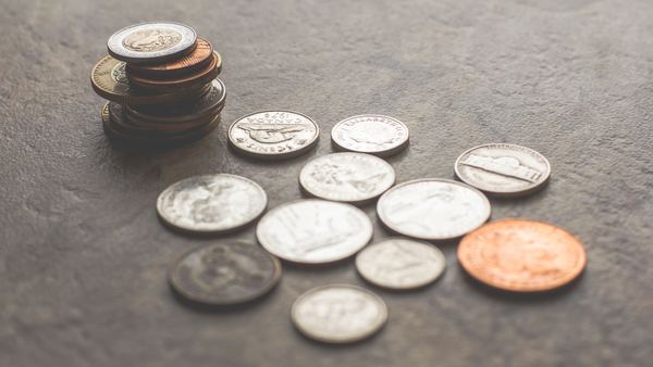 A small pile of US coins scattered on a gray stone surface.