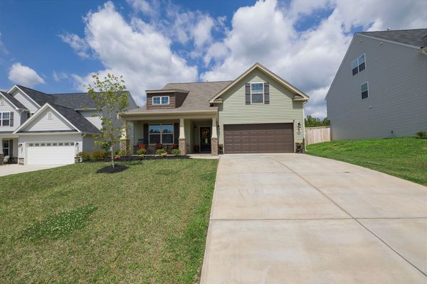 A newly built single-family house with a driveway and lawn
