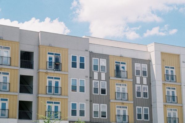 A new mid-rise apartment complex with balconies under a blue sky