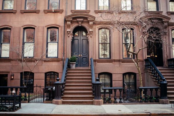 Brownstone townhouses with stoops on a New York street