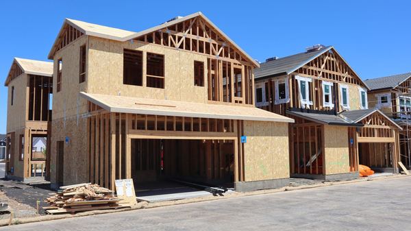 Wood-framed new homes under construction on a residential street