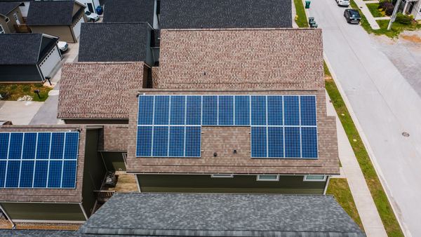 Aerial view of a suburban house with solar panels on the roof