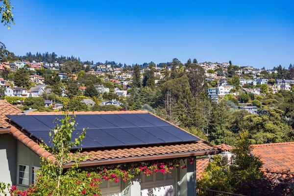Hillside home with black solar panels on its roof