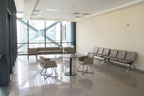 An empty waiting area with rows of chairs in a bright government-style office