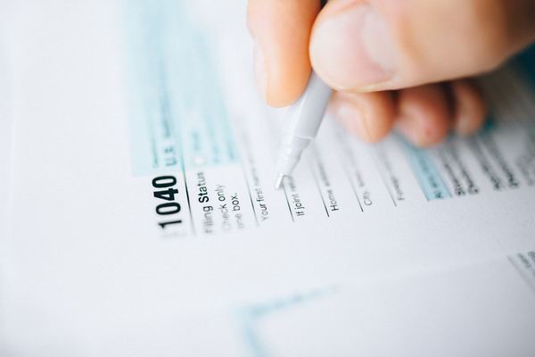 A pen resting on a U.S. 1040 income tax return, shallow focus