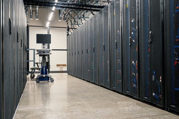 Long aisle between rows of server cabinets inside a data center
