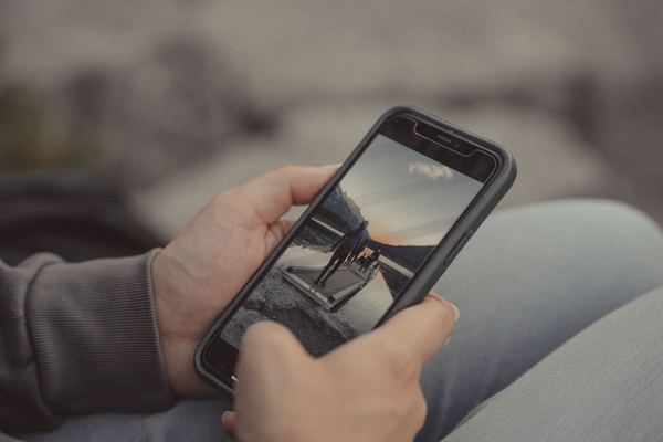 Two hands holding a smartphone showing a photo