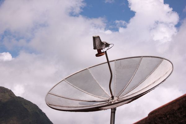 Satellite dish pointed at a cloudy sky